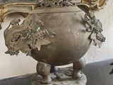 a large vase with a bird on it sitting on a table