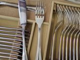 silverware in a box with a knife, fork, spoon and spoon rest
