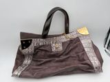 brown and black handbag sitting on a white surface next to an iron ironing board