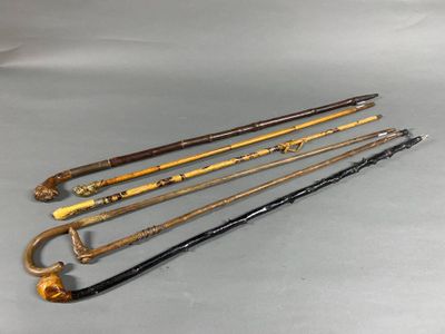 six antique canes are lined up in a row on a table