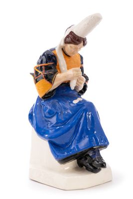 a figurine of a woman sitting on a toilet