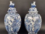 pair of blue and white vases with birds on top of them
