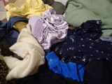 a pile of clothes sitting on top of a bed