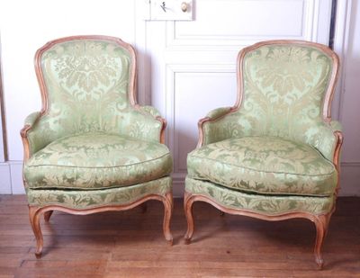 deux chaises vertes placées l'une à côté de l'autre sur un parquet en bois massif