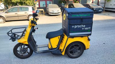 a yellow scooter parked on the side of the road