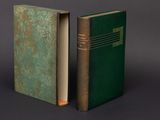 two green books sitting next to each other on a gray surface