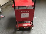 a red cart with a sign on it in a garage