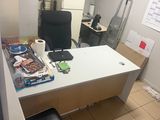 a desk with a chair and a microwave in the room