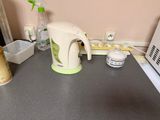 a tea kettle on a counter next to a microwave