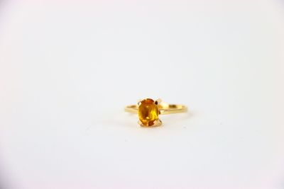 un gros plan d'une bague sertie d'un saphir jaune sur une surface blanche