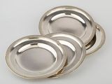 three silver plates with beaded rims on a white surface