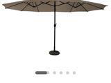 le parasol est ouvert et prêt à être utilisé sur la terrasse
