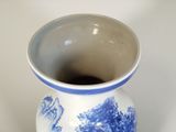 a blue and white vase sitting on a white surface