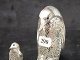 deux figurines d'oiseaux en argent sur fond noir