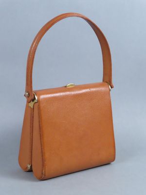 un petit sac à main en cuir beige avec un fermoir doré