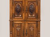 une vieille armoire en bois ornée de sculptures sur le dessus
