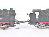 two toy trains sitting side by side on a white surface