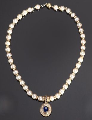 un collier en perles et en or orné d'un pendentif en pierre bleue