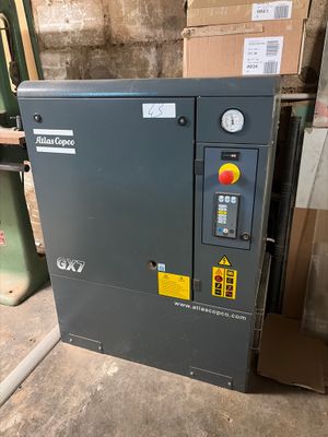 an air compressor sitting on top of a pallet in a warehouse
