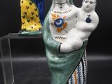 trois figurines en céramique représentant une femme tenant un enfant dans ses bras et un homme tenant un bébé