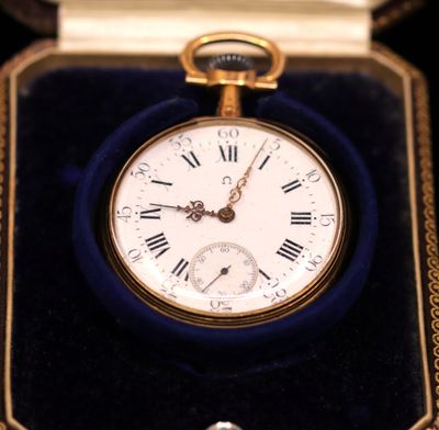 a small gold pocket watch with roman numerals in it