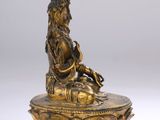 a gold statue of a woman sitting on top of a bowl