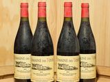 trois bouteilles de vin sont posées sur un tonneau en bois devant un mur en bois