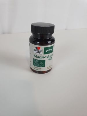 une bouteille de liquide posée sur une surface blanche