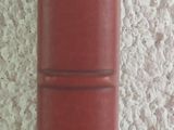 a stack of red books sitting on a white table