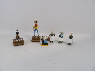 cinq figurines représentant un homme et une femme assis sur un banc