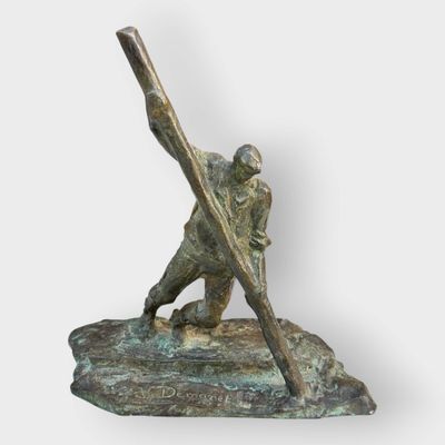 bronze statue of a baseball player holding a bat on a rock