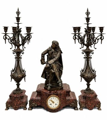 une statue représentant un homme assis sur une table, à côté de trois chandeliers