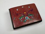 a small red box with blue and green designs on it