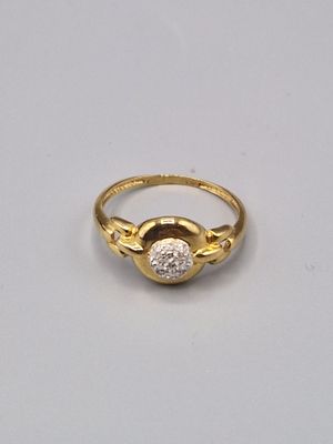 gros plan d'une bague en or et diamants sur une surface blanche