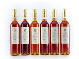 four bottles of wine are lined up on a white surface