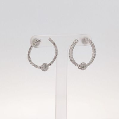 une paire de boucles d'oreilles créoles en diamant exposées sur un fond blanc