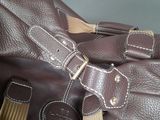 a brown leather bag with a tan strap on it