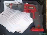 a cordless drill in a case with papers on the table