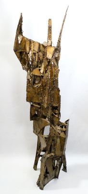 sculptures made of metal are stacked on top of each other on a white surface