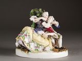 a figurine of a man and a woman sitting on a chair