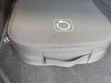 une valise à l'arrière d'une voiture, attachée par une ceinture de sécurité