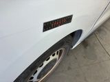 a close up of a white car with a sticker on it