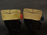 pair of black mannequins with hats and tassels on them