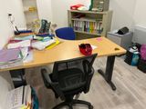 a desk with a chair and bookshelf in the corner