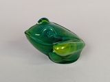 une figurine de grenouille en verre posée sur une surface blanche