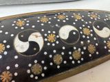 a black and gold plate with white and yellow designs on it