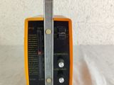 yellow and black radio sitting on top of a white table