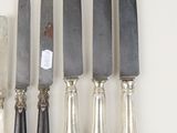 six knives are lined up next to each other on a table