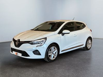 Une voiture blanche est garée dans une pièce au sol gris.