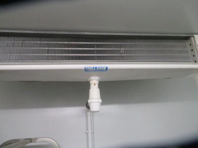 a white air conditioner sitting on a shelf next to a wall
